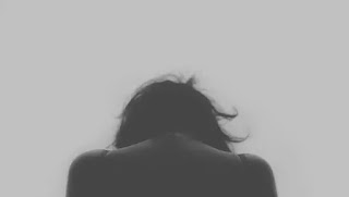 俯いている女性の後ろ姿