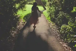 小道を歩く女性の後ろ姿